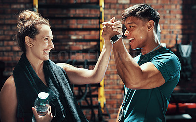 Buy stock photo Cropped shot of two cheerful young sportspeople cheering while working out in a gym