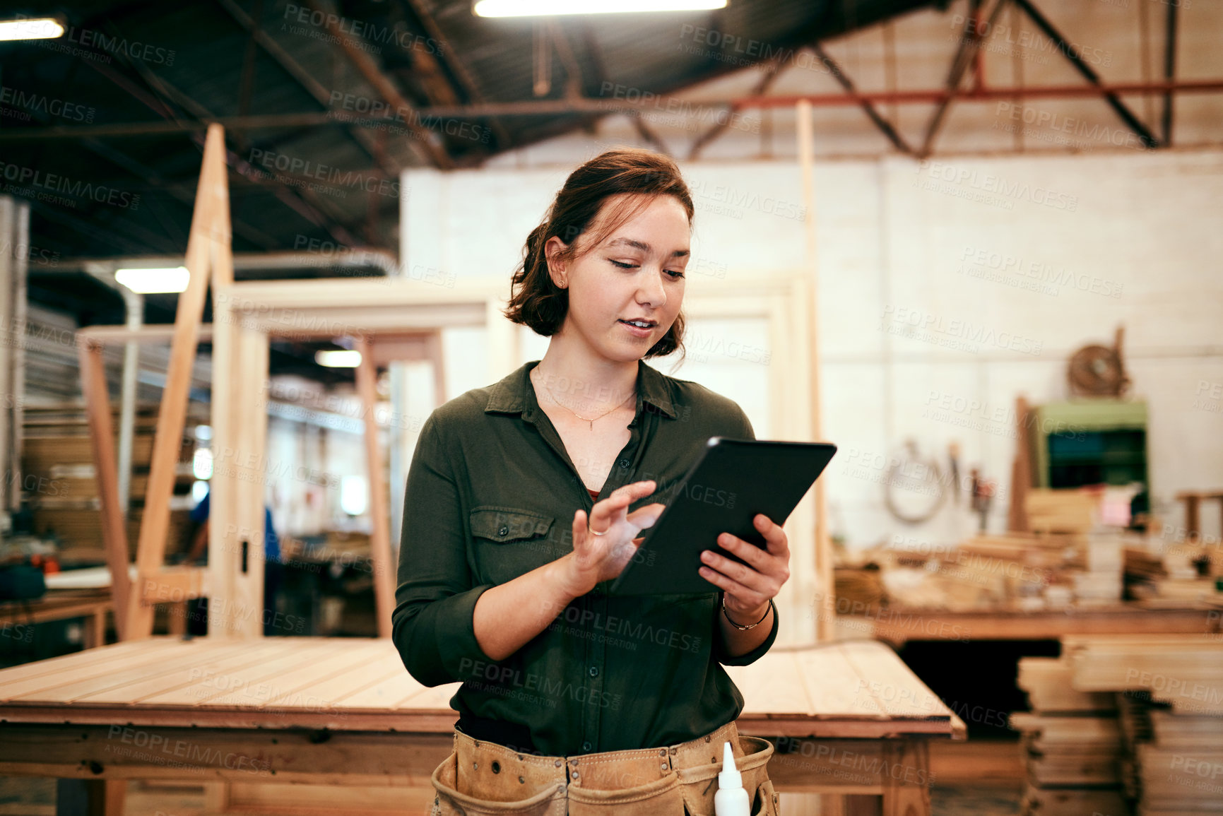 Buy stock photo Shot of a female carpenter using a digital tablet in her workshop