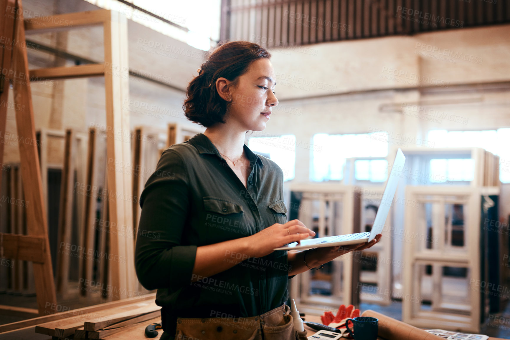Buy stock photo Shot of a female carpenter using a laptop in her workshop