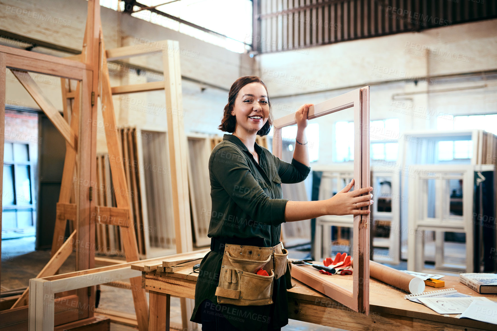 Buy stock photo Cropped shot of a female carpenter holding a wooden frame in her workshop
