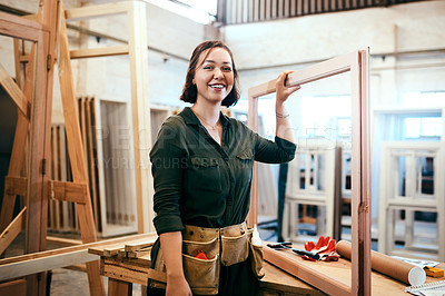 Buy stock photo Cropped shot of a female carpenter holding a wooden frame in her workshop