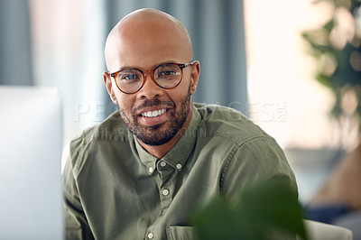 Buy stock photo Cropped shot of a young businessman sitting behind a computer in his office