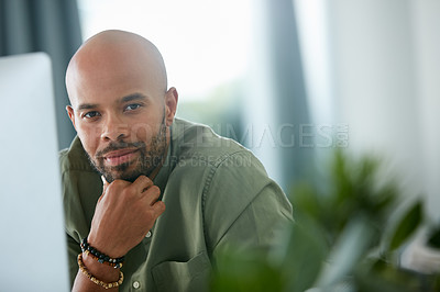 Buy stock photo Cropped shot of a young businessman sitting behind a computer in his office