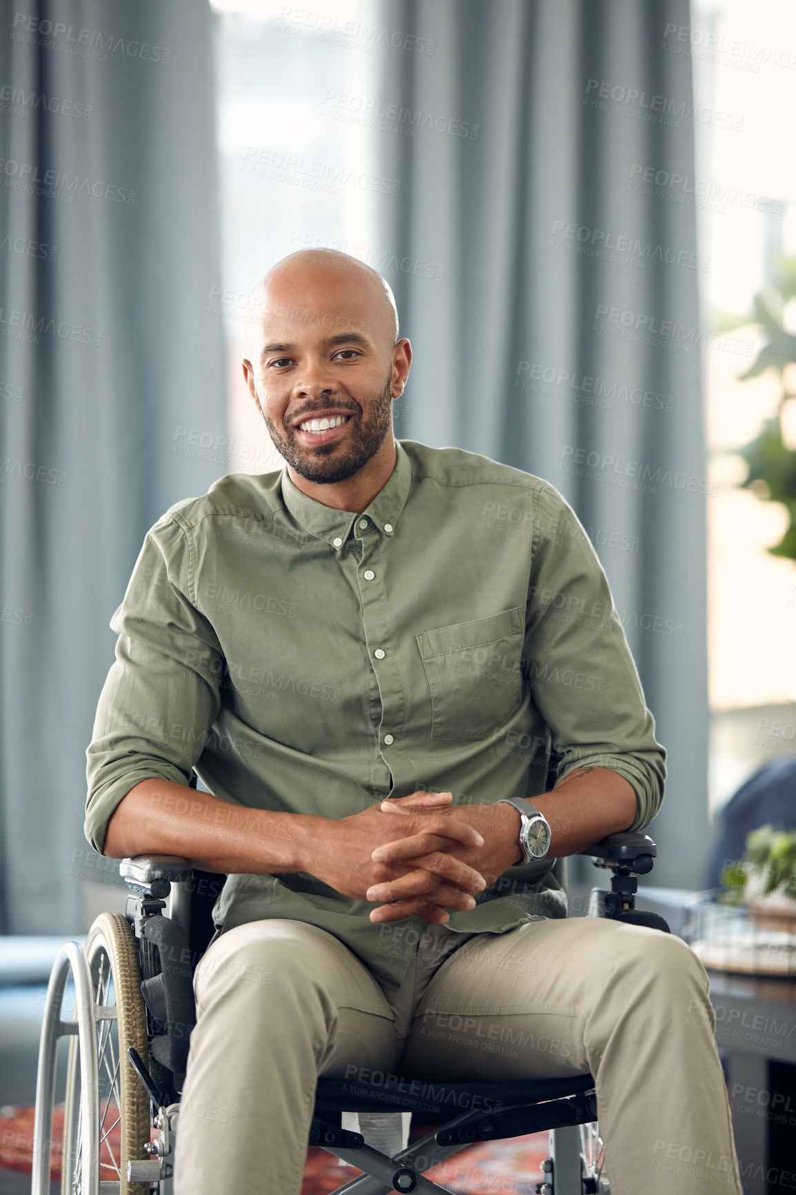 Buy stock photo Cropped shot of a young man sitting in his wheelchair at home