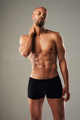 Buy stock photo Portrait of a handsome young man posing in underwear against a grey background