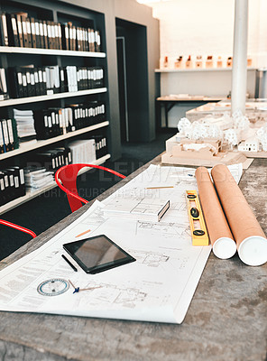 Buy stock photo Still life shot of an architect's blueprints placed on a desk in a modern office
