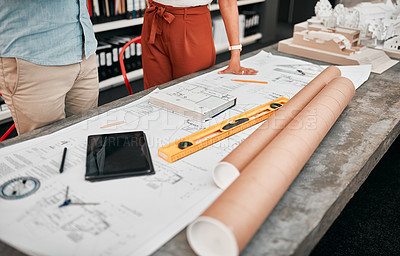 Buy stock photo Cropped shot of two unrecognizable architects working with blueprints in a modern office