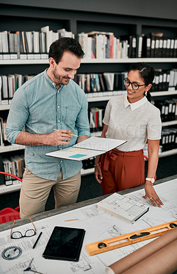 Buy stock photo Cropped shot of two aspiring young architects working together in a modern office