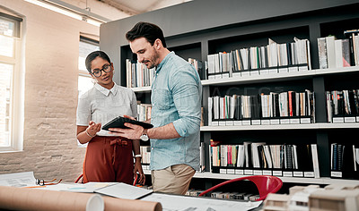 Buy stock photo Cropped shot of two aspiring young architects using a digital tablet while working together in a modern office