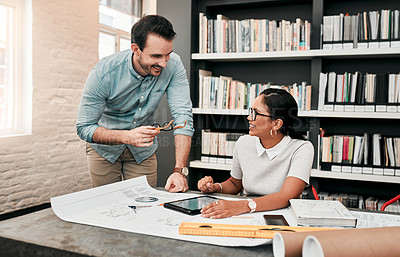 Buy stock photo Cropped shot of two aspiring young architects using a digital tablet while working together in a modern office