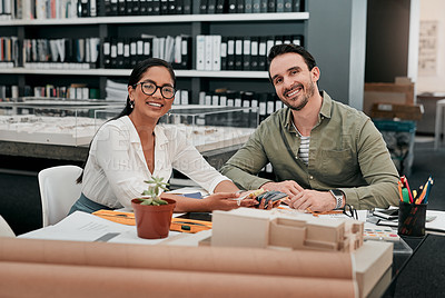 Buy stock photo Cropped portrait of two aspiring young architects smiling while working together in a modern office