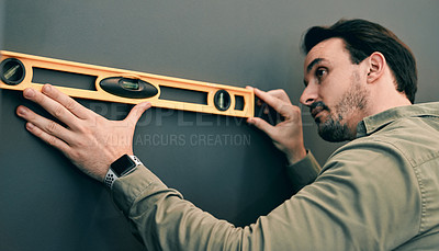 Buy stock photo Cropped shot of a young architect holding a spirit-level against a wall