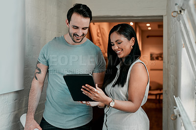 Buy stock photo Cropped shot of two young designers looking at something on a digital tablet
