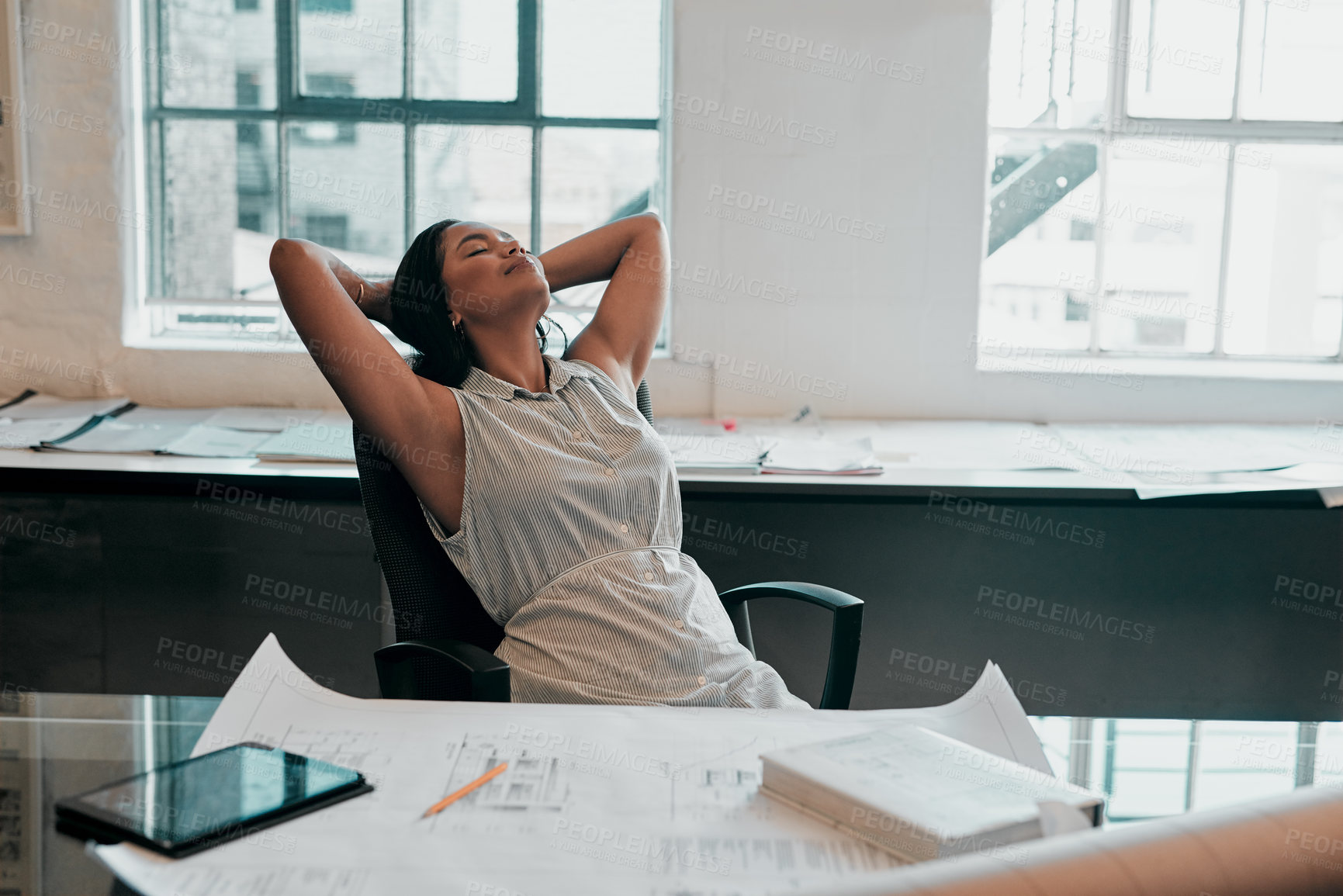 Buy stock photo Cropped shot of a female architect looking relaxed at her desk