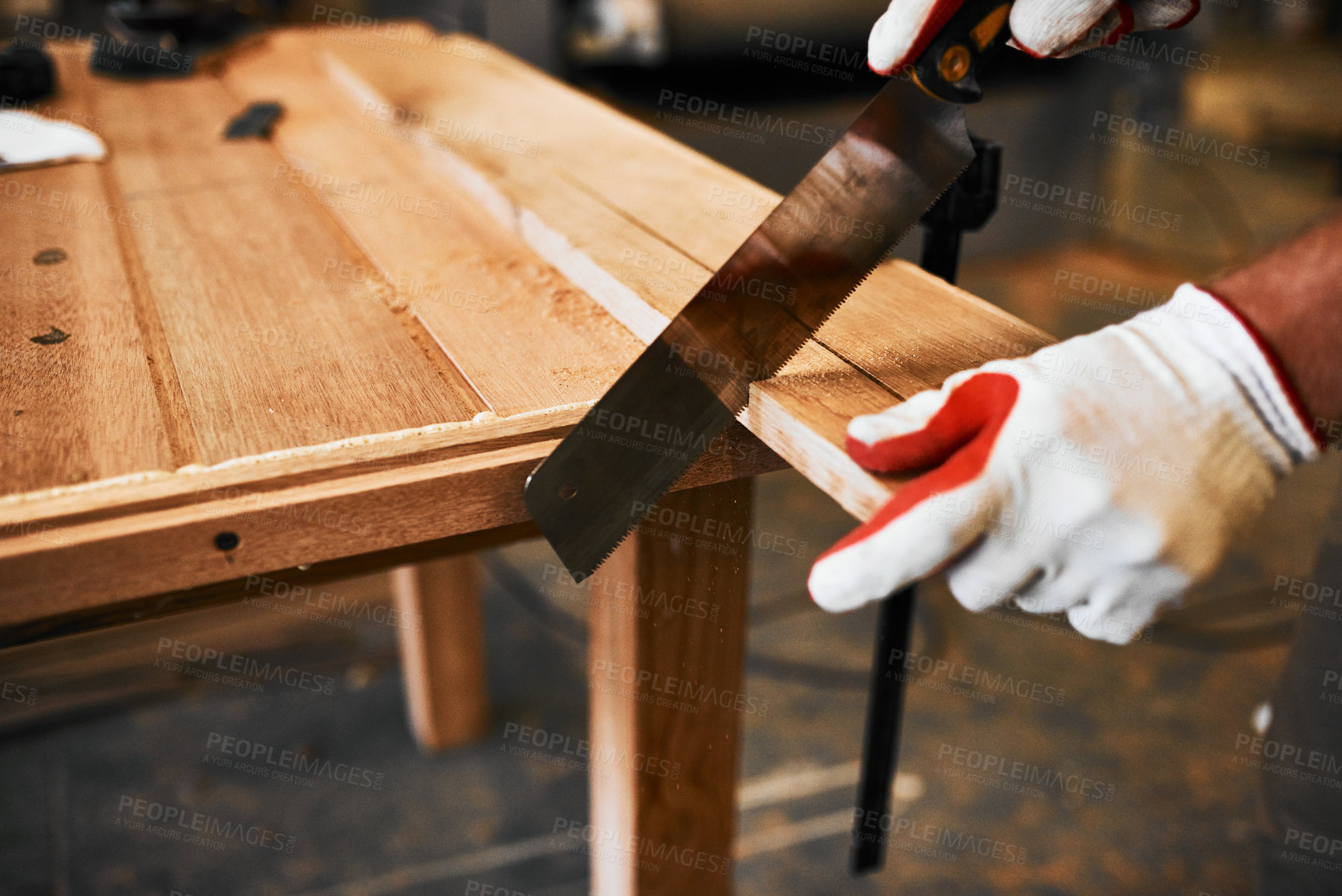 Buy stock photo Cropped shot of an unrecognizable carpenter cutting wood inside a workshop