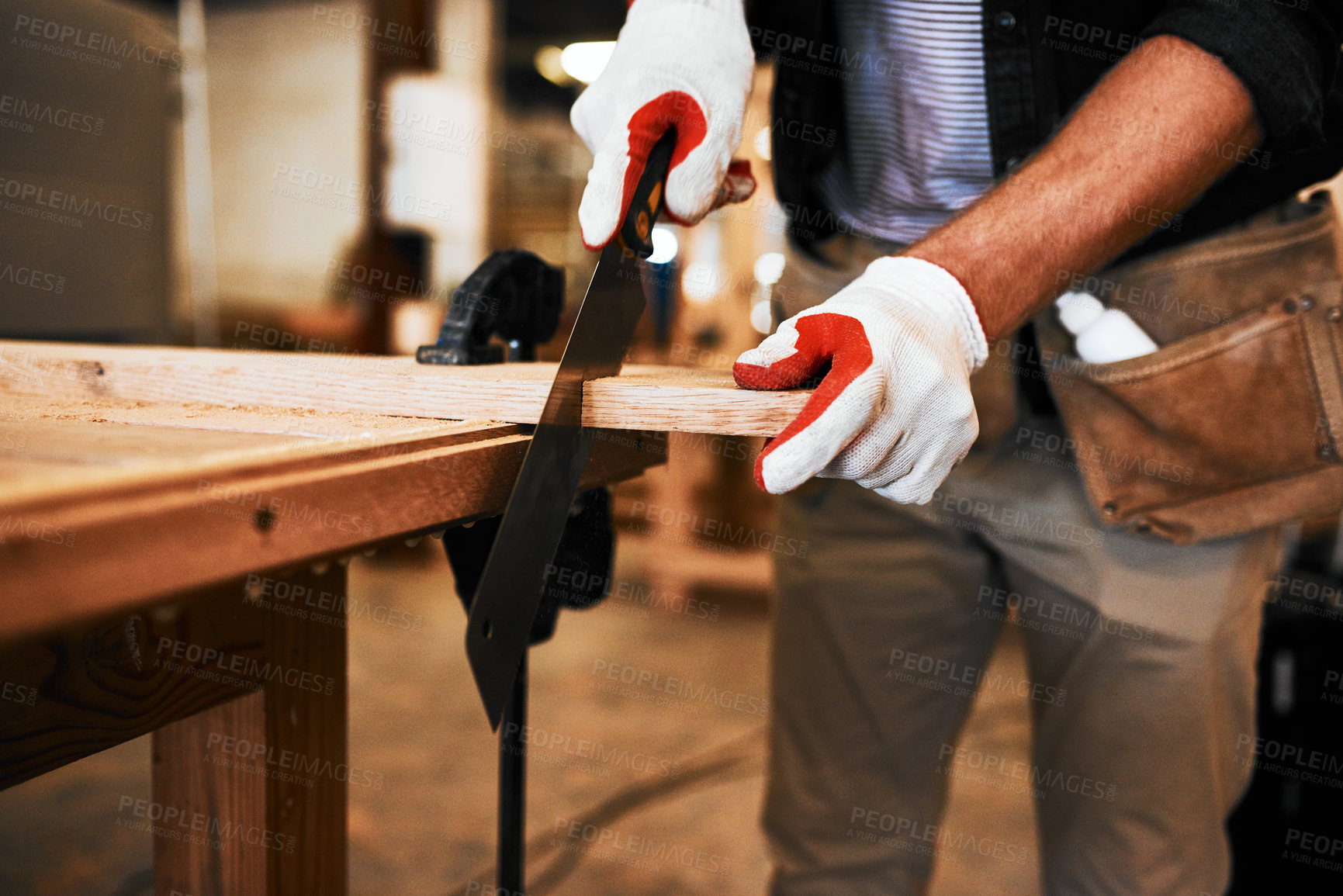 Buy stock photo Cropped shot of an unrecognizable carpenter cutting wood inside a workshop