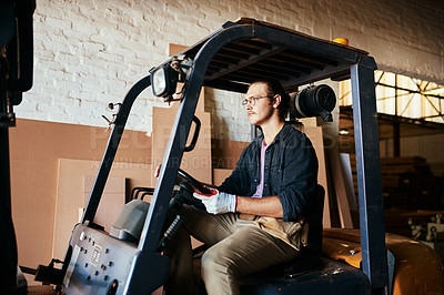 Buy stock photo Small business, man and driving forklift at warehouse for woodwork, furniture and wood. Male person, employee and serious at factory or workshop for carpentry, manufacturing and supply chain