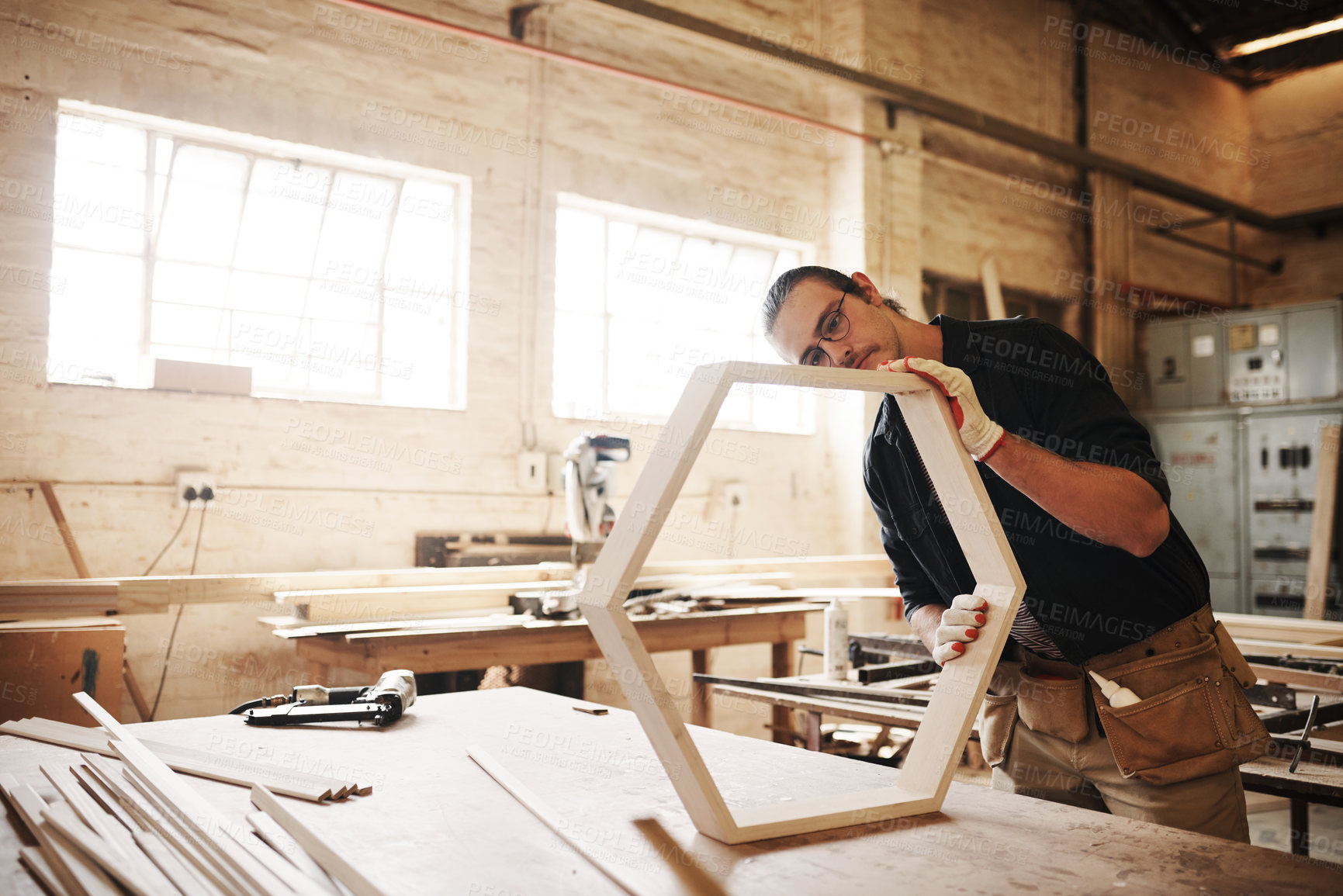 Buy stock photo Warehouse, man and carpentry with furniture as handyman for woodwork, supply chain or manufacturing. Male person, small business and serious as employee with tools, equipment or material for crafting