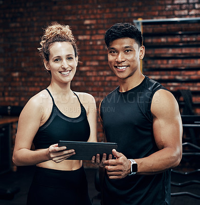 Buy stock photo Cropped shot of two sporty young people holding a digital tablet in the gym