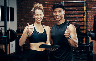 Buy stock photo Cropped shot of two sporty young people holding a digital tablet in the gym