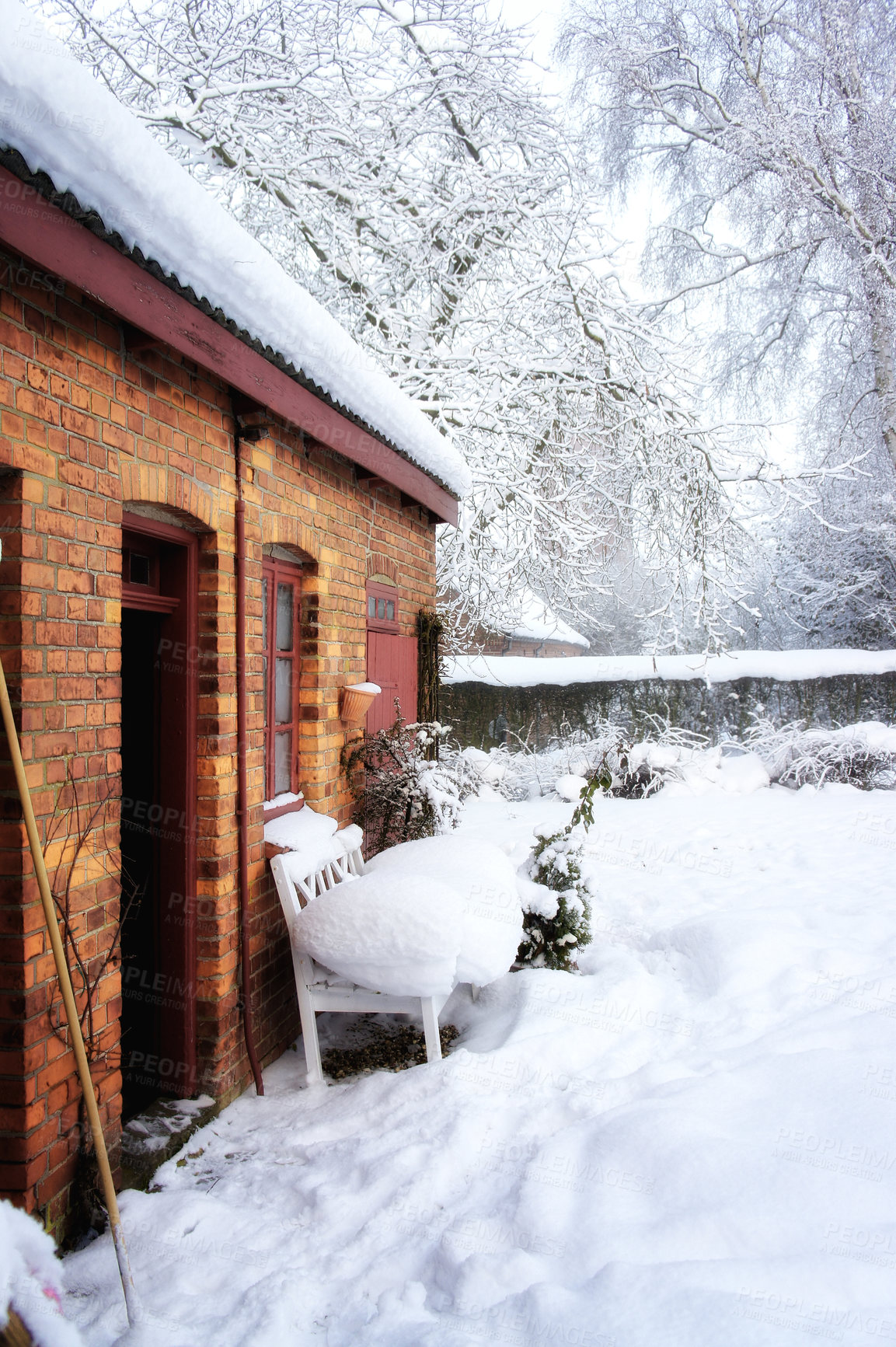 Buy stock photo Quiet old house in snow landscape and frozen garden. A red brick cottage in Europe with thick white frost covered yard in winter with copy space. Magical wonderland of snowfall in Scandinavia