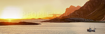 Buy stock photo A single fishing boat on a lake with the mountains in the background at sunset with copy space. Calm, serene, tranquil, ocean or sea at dawn in the remote and peaceful mountainous wilderness