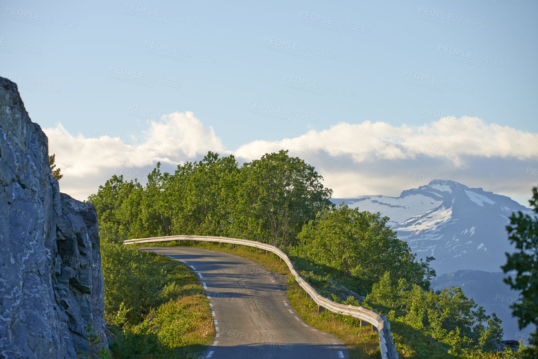 Buy stock photo Empty scenic road in mountains during summertime in Nordland. Secluded quiet and peaceful street on the countryside surrounded by lush green trees. Remote travel location in springtime with copyspace