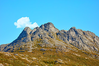 Buy stock photo Landscape view of mountains, blue sky with clouds and copy space in Norway. Hiking, discovering scenic countryside and rough terrain. Sun shining on vast background of nature expanse and hiking trail