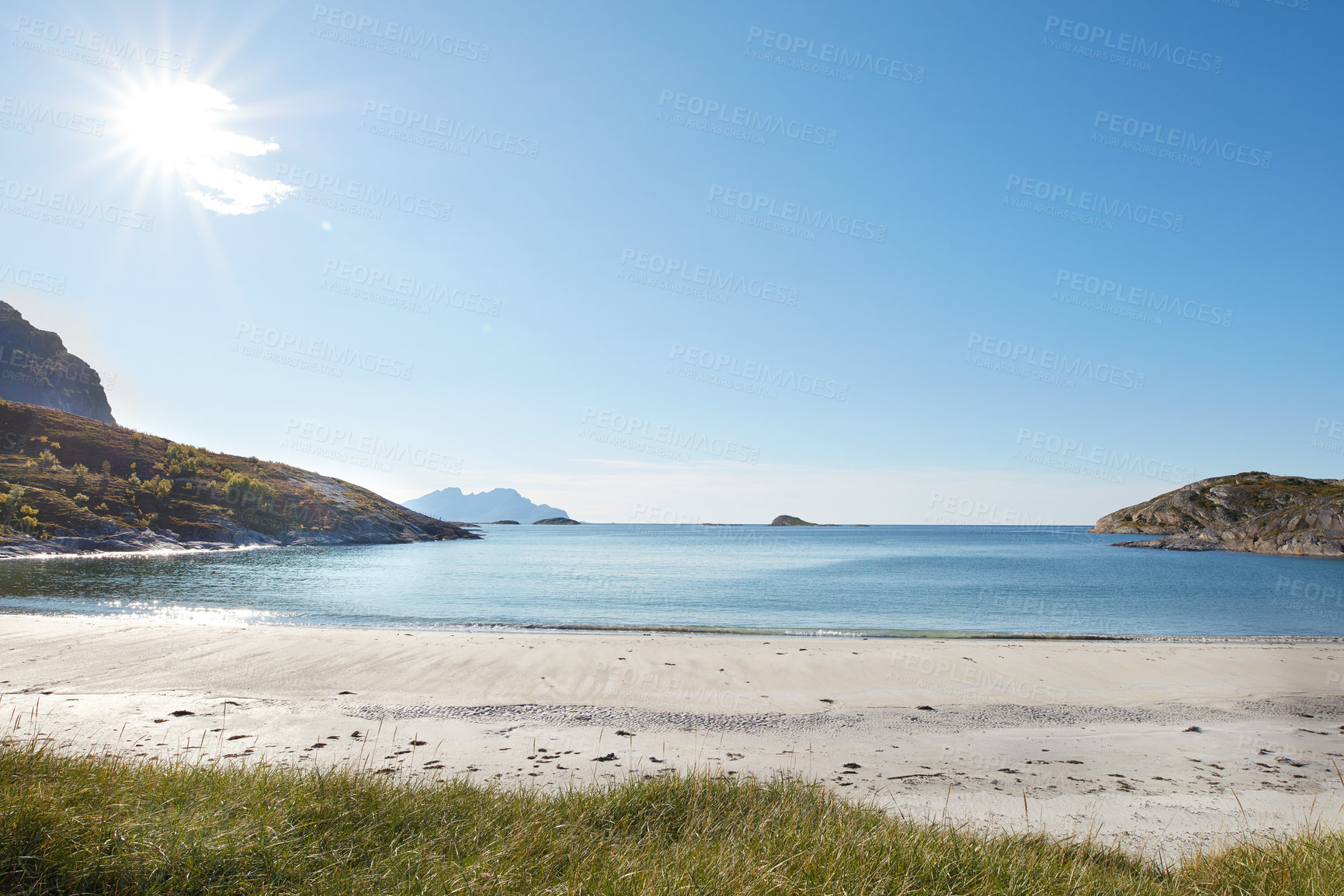 Buy stock photo Copyspace at the beach with blue sky background above the horizon with lens flare. Calm ocean waves across an empty sea along the shore. Peaceful and tranquil landscape for a relaxing summer holiday