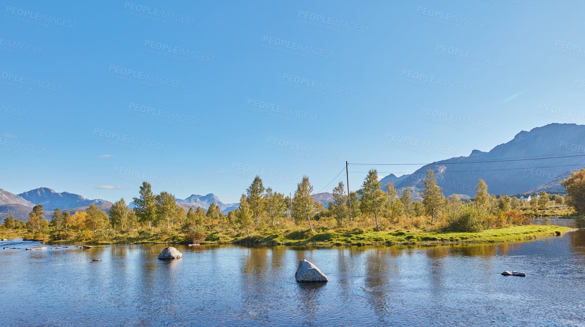 Buy stock photo Scenic view of a lake, ocean or sea with blue sky and copy space. Uncultivated trees, bushes, shrubs around a bay of water in Norway. Landscape of calm, serene, peaceful, quiet nature pond with rocks