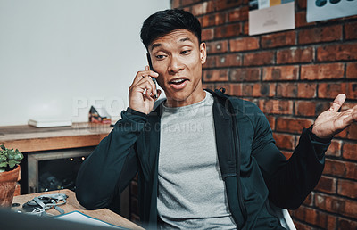 Buy stock photo Cropped shot of a handsome young male fitness instructor taking a phonecall while working in a gym