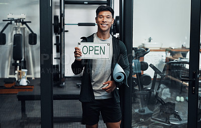 Buy stock photo Cropped portrait of a handsome young male fitness instructor holding up a sign that says 
