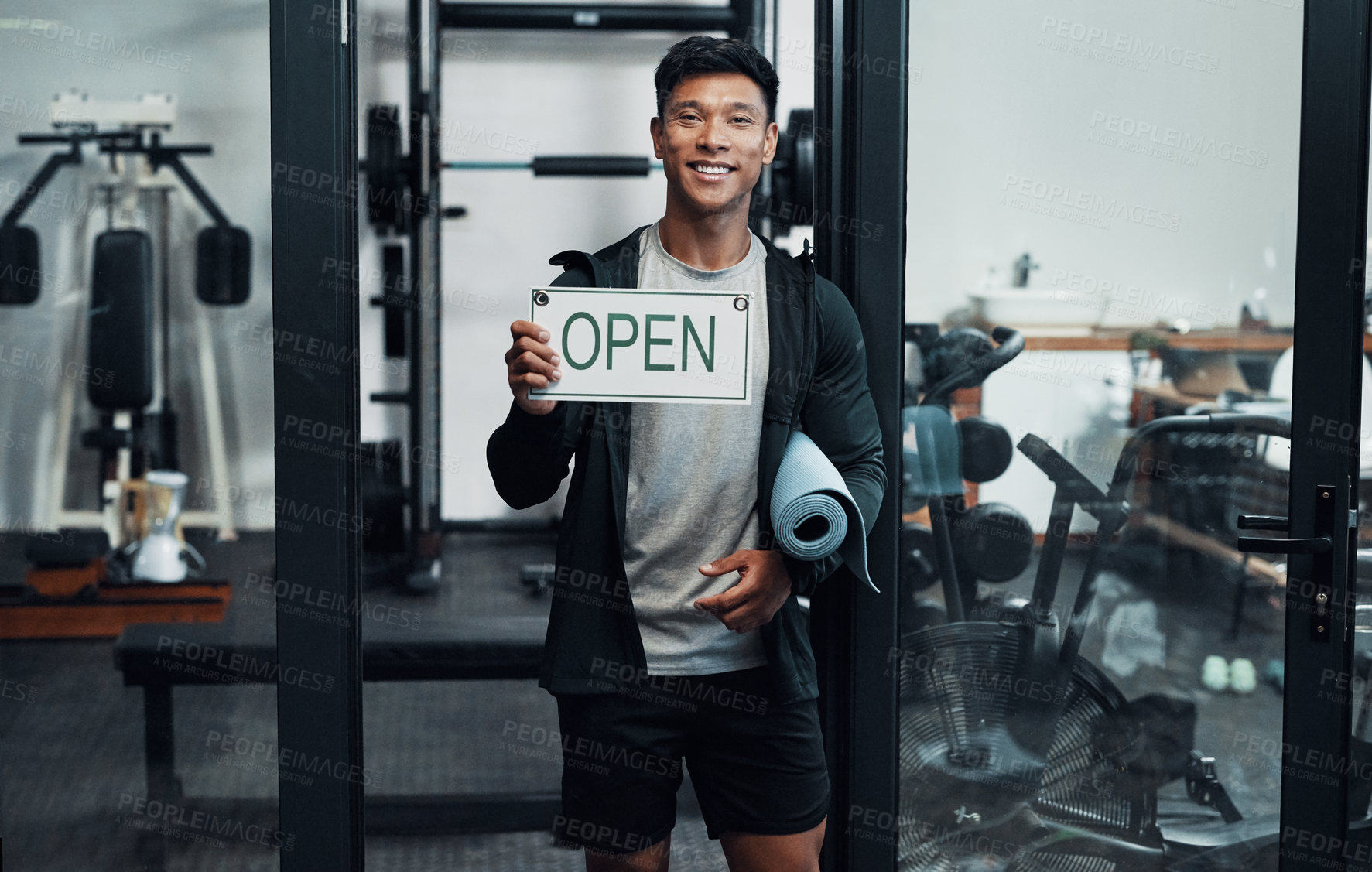 Buy stock photo Cropped portrait of a handsome young male fitness instructor holding up a sign that says 