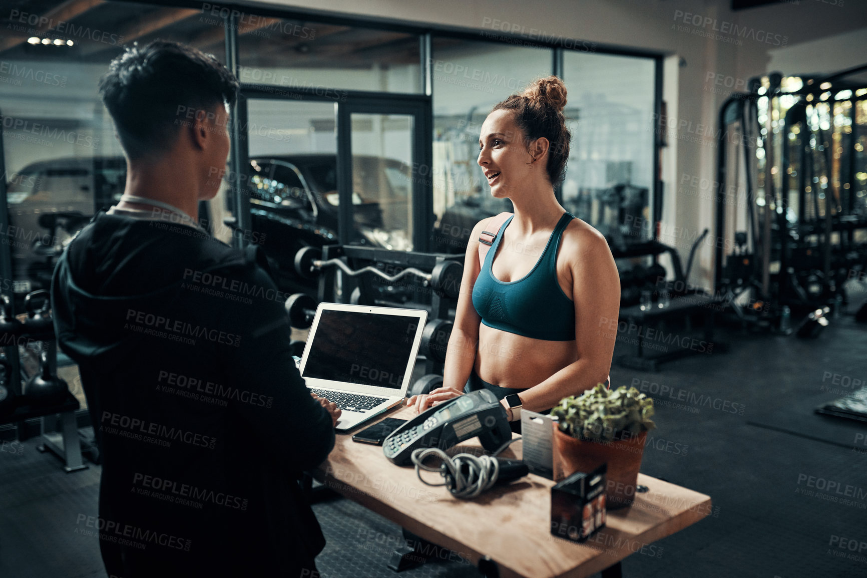 Buy stock photo Cropped shot of an attractive young sportswoman talking to a  male fitness instructor at the reception of a gym
