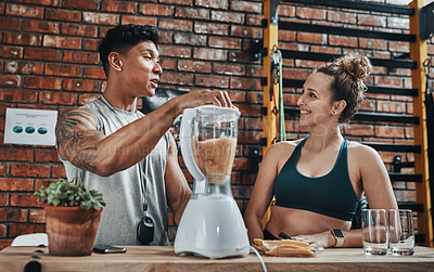 Buy stock photo Cropped shot of two young sportspeople making fruit milkshake while working in a gym