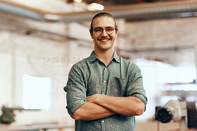 Buy stock photo Portrait of a young carpenter posing with his arms folded inside a workshop