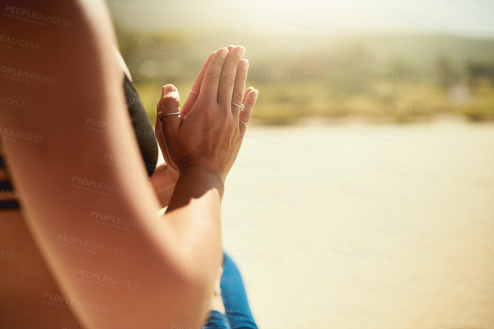 Buy stock photo Cropped shot of an unrecognizable woman practising yoga on the beach