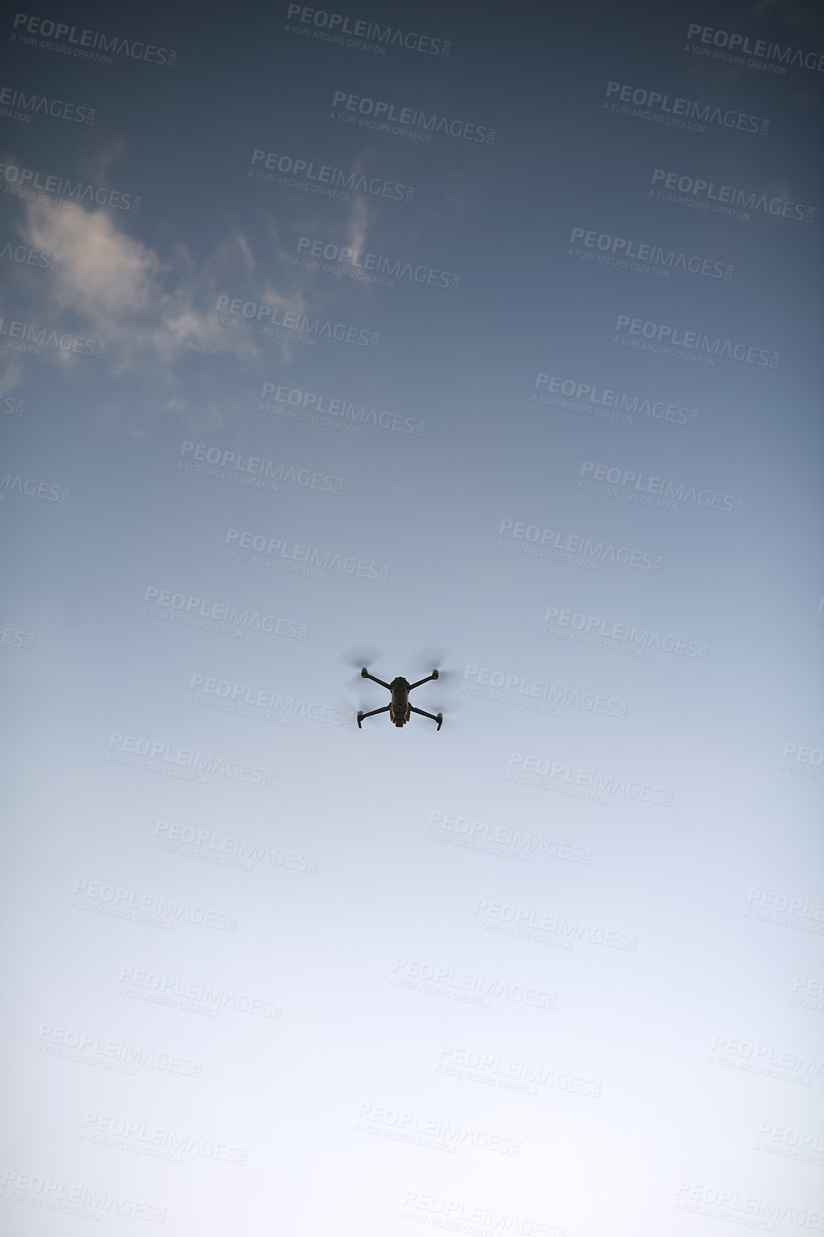 Buy stock photo Low angle shot of a drone flying high in the sky