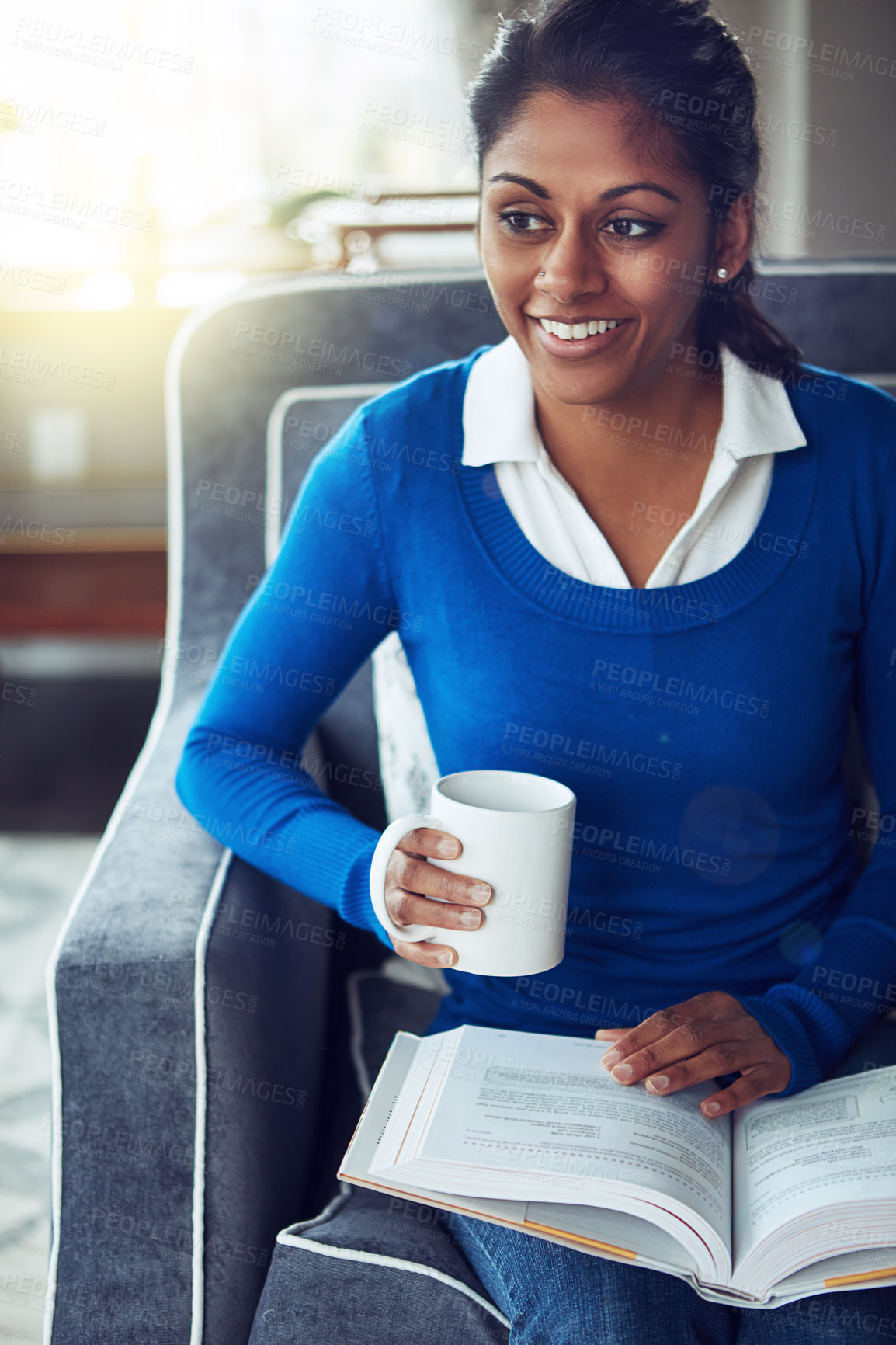 Buy stock photo Shot of a young woman relaxing on the sofa with a cup of coffee and a book at home