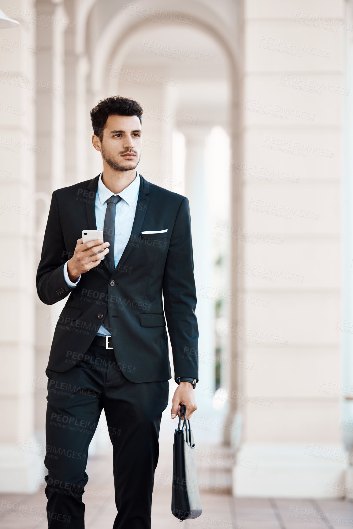 Buy stock photo Cropped shot of a young handsome businessman using a cellphone outside