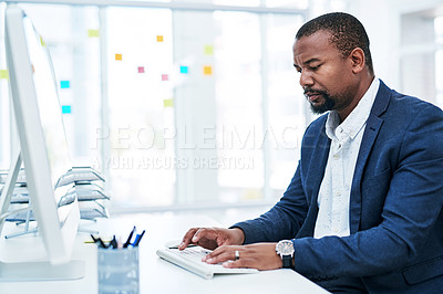 Buy stock photo Shot of a mature businessman working on a computer in an office