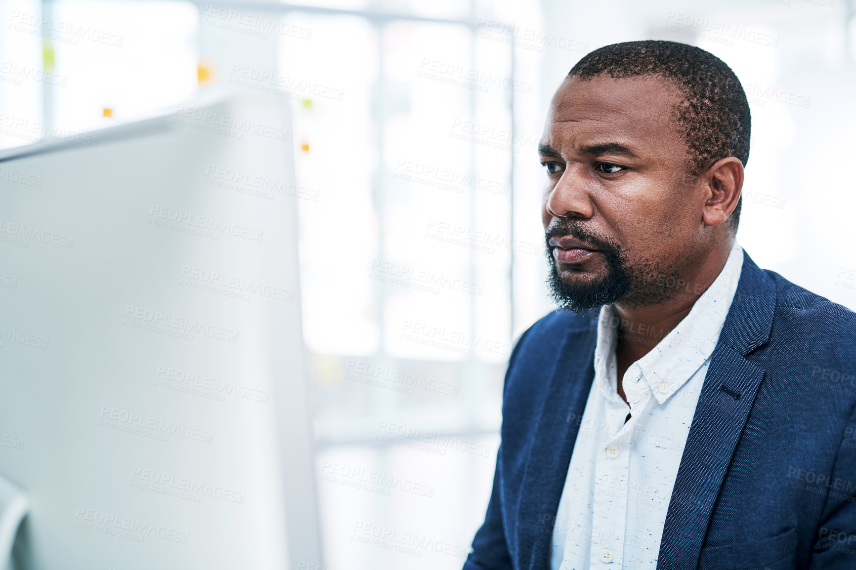 Buy stock photo Shot of a mature businessman working on a computer in an office