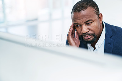 Buy stock photo Shot of a mature businessman looking stressed out while working on a computer in an office