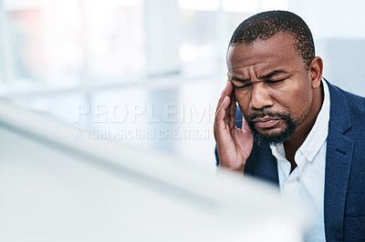 Buy stock photo Shot of a mature businessman looking stressed out while working on a computer in an office