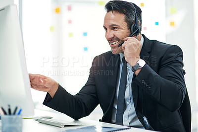 Buy stock photo Shot of a mature businessman using a headset while working on a computer in an office