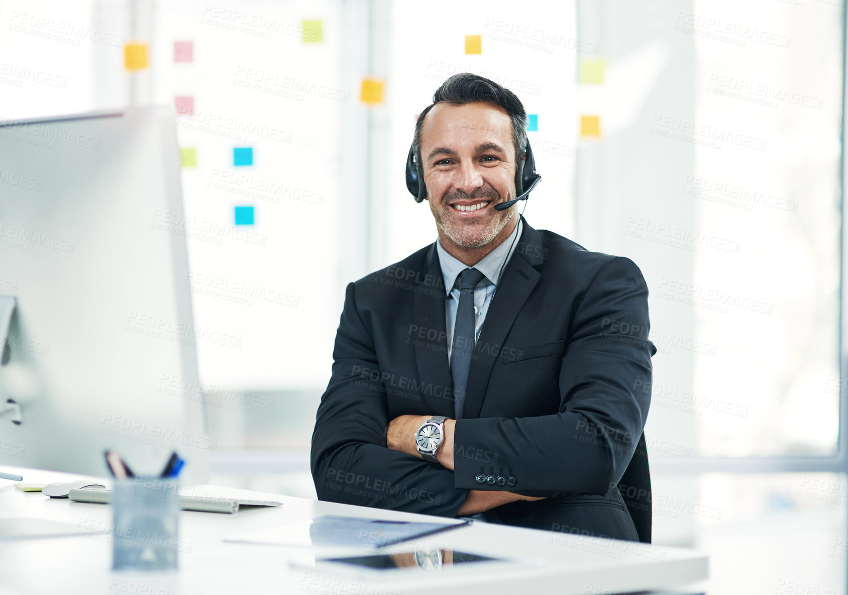 Buy stock photo Portrait of a mature businessman wearing a headset while working in an office