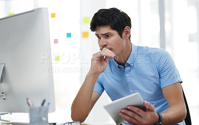 Buy stock photo Shot of a young businessman looking concerned while working in an office