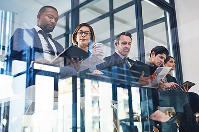 Buy stock photo Cropped shot of a diverse group of businesspeople sitting in line for an interview in a modern office