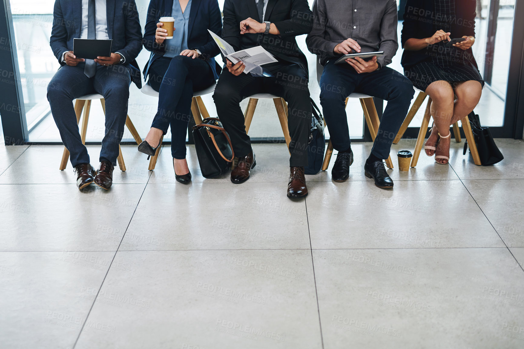 Buy stock photo Cropped shot of a group of unrecognizable businesspeople sitting in line for an interview in a modern office