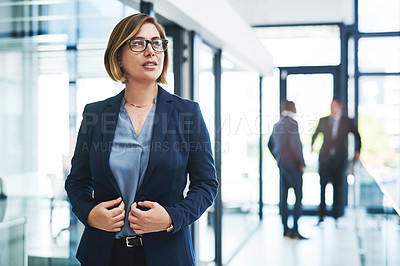 Buy stock photo Cropped shot of an attractive young businesswoman looking thoughtful in a modern office with her colleagues in the background